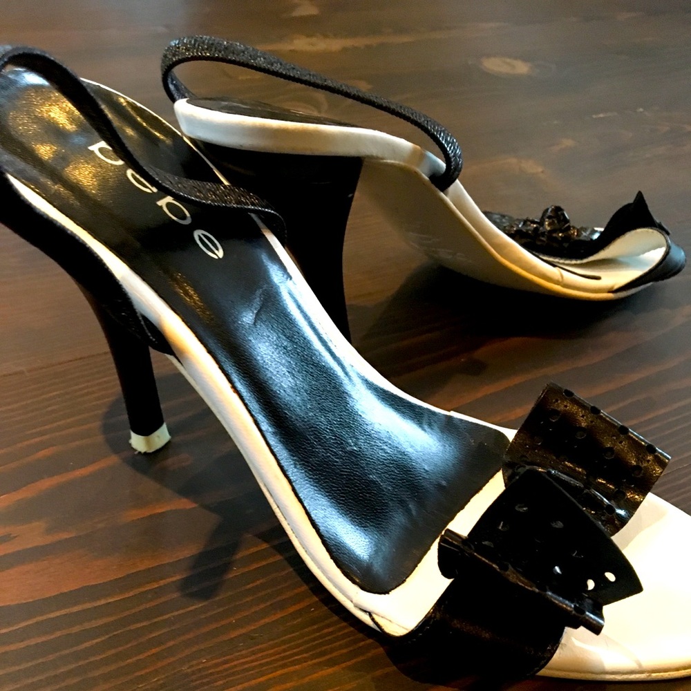 white and black strappy heels. Patent bow on toe strap with elastic heel strap